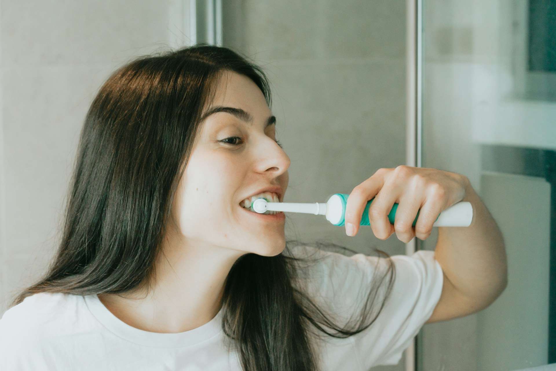 Woman brushing her teeth before breakfast