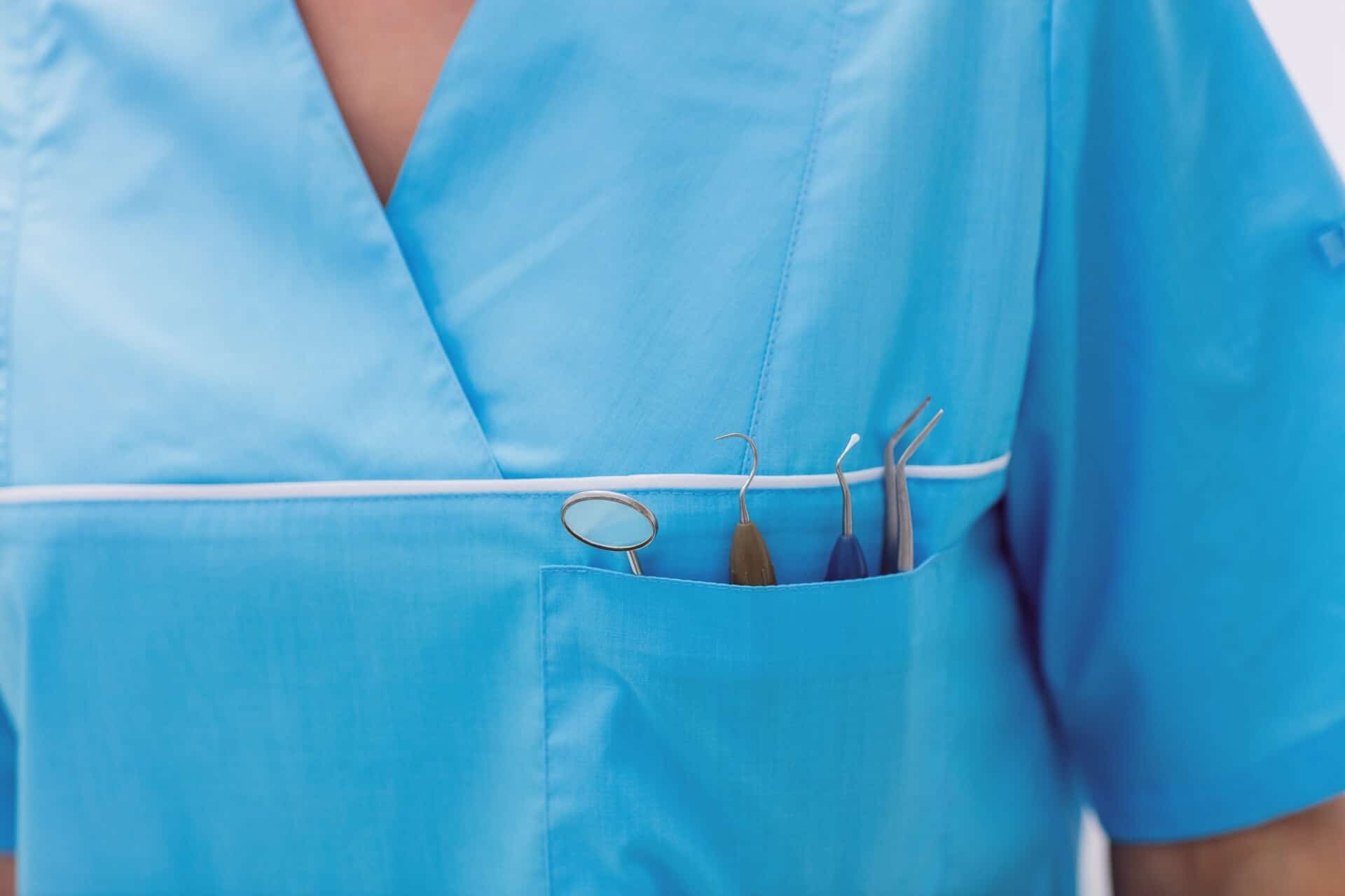 close up of a dental hygienist with dentist tools in front pocket