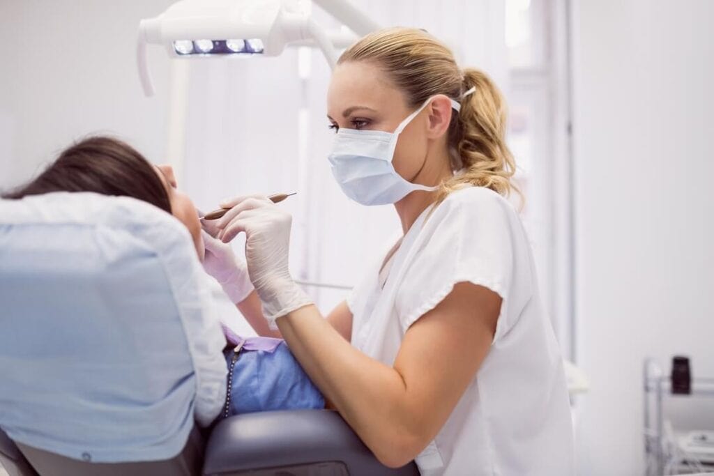 dental hygienist examining female patient (1)