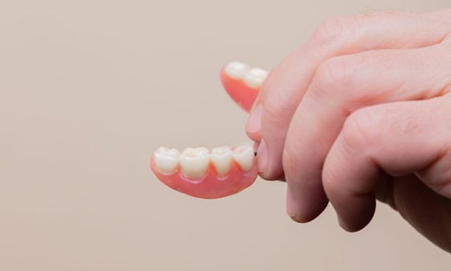 bottom row dentures held by persons hand